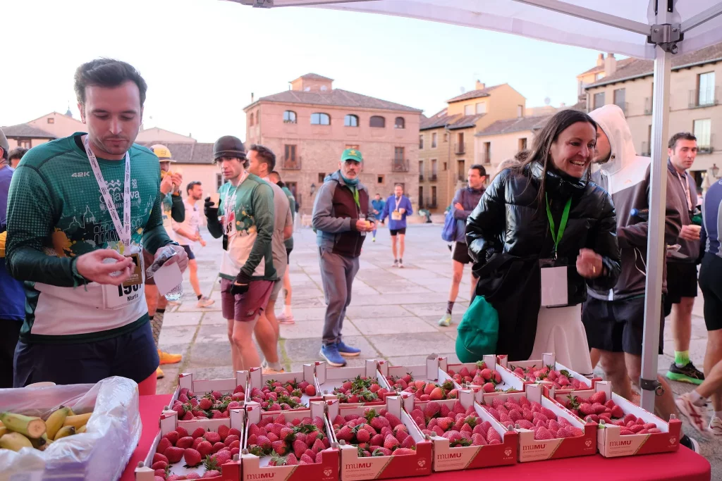 Corredores de la Media Maratón Cajaviva 2026 de Segovia en el punto de avituallamiento de MUMU Berries.